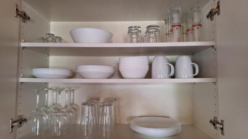 a cabinet filled with glasses and bowls and glassware at Köpplmühle Apartment in Freistadt