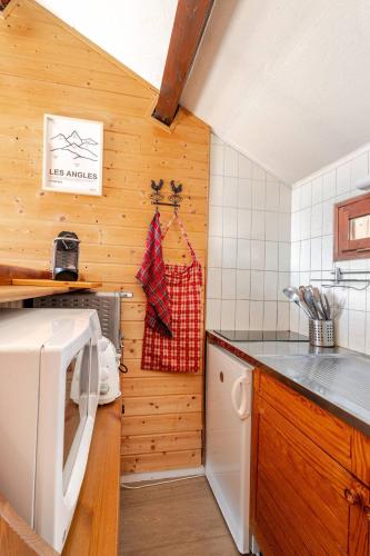 - une petite cuisine avec des murs en bois et un comptoir dans l'établissement vue du Lac, aux Angles