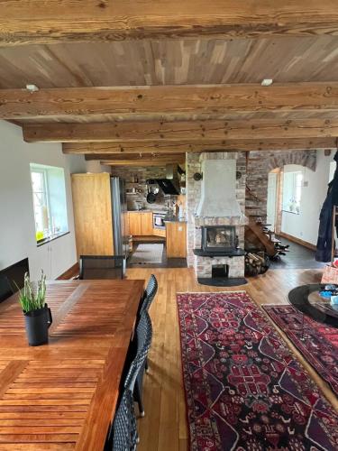 a living room with a wooden table and a fireplace at Half-timbered house in Österlen in Sjöbo