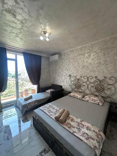 a bedroom with two beds and a large window at Dracena Guesthouse in Ravda