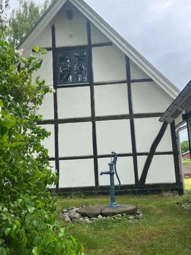 a house with a window and a statue in the yard at Half-timbered house in Österlen in Sjöbo