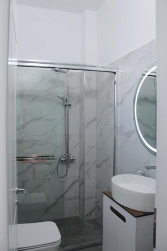 a bathroom with a shower and a toilet and a sink at Guest House Adi Hoxha in Berat