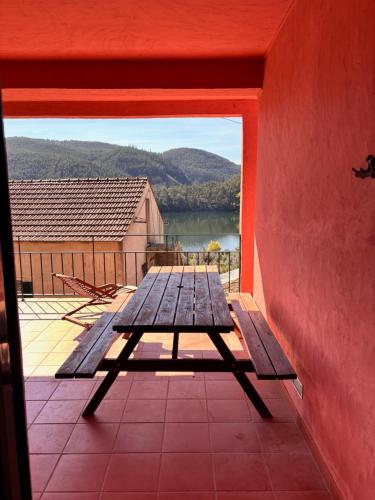 a picnic table on a porch with a view of a lake at New Flat with View over the River Zezere in Casalinho de Santana