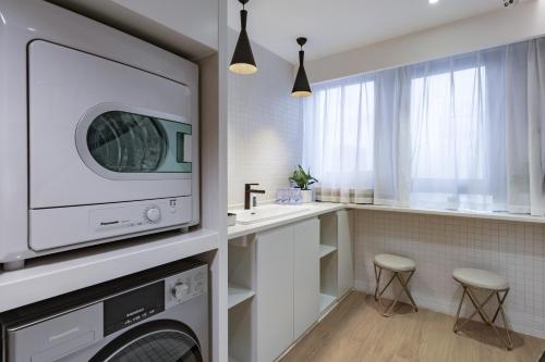 a laundry room with a washer and dryer at Atour Hotel (Suzhou Wujiang Wuyue Plaza) in Suzhou
