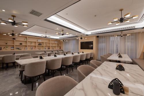 a conference room with rows of tables and chairs at Atour Hotel (Suzhou Wujiang Wuyue Plaza) in Suzhou