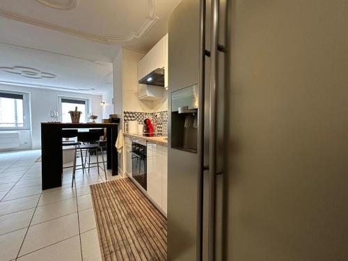une cuisine avec un réfrigérateur et une table à l'intérieur dans l'établissement MH Habitat au cœur du centre ville, à Mulhouse