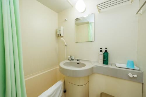 a bathroom with a sink and a mirror at ビジネスホテル寿屋 in Handa