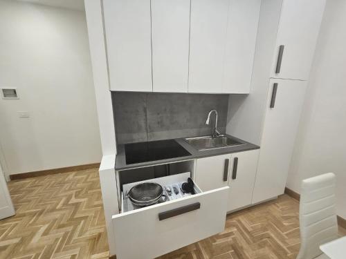 a small kitchen with white cabinets and a sink at BEI SOGNI LUXURY in centro, con parcheggio in convenzione in Cosenza