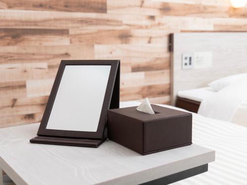 a tablet and a box on a table at Super Hotel Kyoto Shijokawaramachi in Kyoto