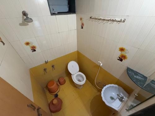 a small bathroom with a toilet and a sink at Hotel Temple Sai in Shirdi