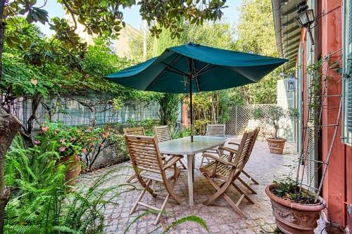 une table et des chaises avec un parasol sur une terrasse dans l'établissement L'ORANGER maison pittoresque et confortable proche des plages, Croisette et centre-ville, à Cannes
