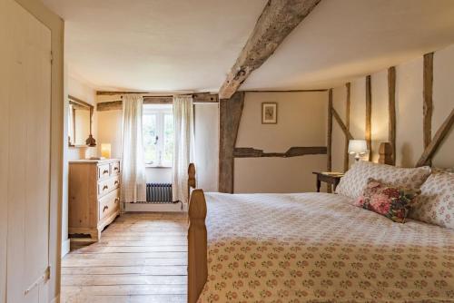 a bedroom with a large bed and a window at Bertie's Cottage by Keepers Cottages in Robertsbridge