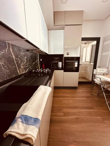 a kitchen with white cabinets and a black counter top at luxueux S2 a Jardin de Carthage in Sidi Daoud