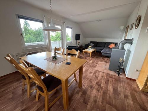 une salle à manger et un salon avec une table et des chaises dans l'établissement Haus Waldzeit, inclusief bedlinnen handdoeken en eindservice, à Frankenau