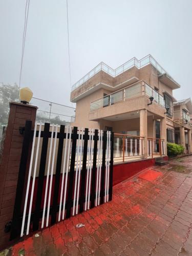 una cerca en blanco y negro frente a un edificio en Royal Villa 1 - Big Pvt Swimming Pool - 2BHK Villa - Lonavala, en Lonavala
