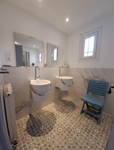 La salle de bains est pourvue d'un lavabo et d'une chaise bleue. dans l'établissement LE CLOS BUCCI - Golfe de Saint-Tropez - Les hauts de Grimaud, villa avec vue exceptionnelle, à Grimaud