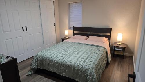 a bedroom with a bed and two lamps on two tables at Alanas house in Denver