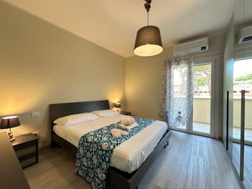 a bedroom with a bed and a large window at Borgo Del Navigatore in Marina di Grosseto