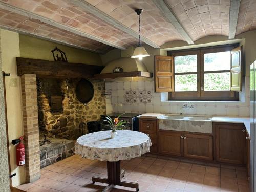 a kitchen with a table in the middle of it at Can LLorens in Llagostera