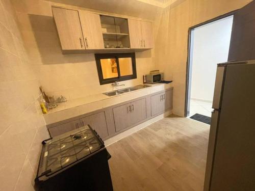 a small kitchen with a sink and a refrigerator at KARIBUci confortable refuge in Cocody Angré CGK in Abidjan
