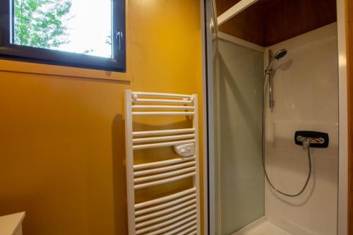 La petite salle de bains est pourvue d'une douche et d'un lavabo. dans l'établissement Chalet du domaine de rafin, à Lamothe-Montravel