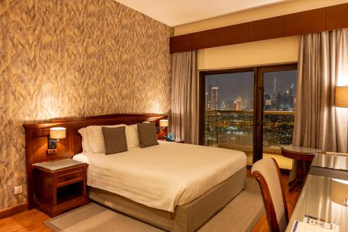 a hotel room with a bed and a large window at Majestic City Retreat Hotel in Dubai