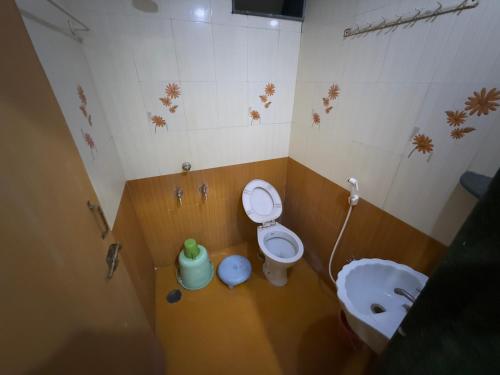 a bathroom with a toilet and a sink at Hotel Temple Sai in Shirdi