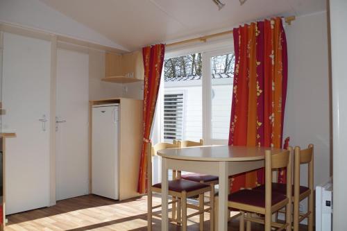 a kitchen with a table and chairs and a window at Camping Le Balcon de Chartreuse in Miribel-les-Échelles