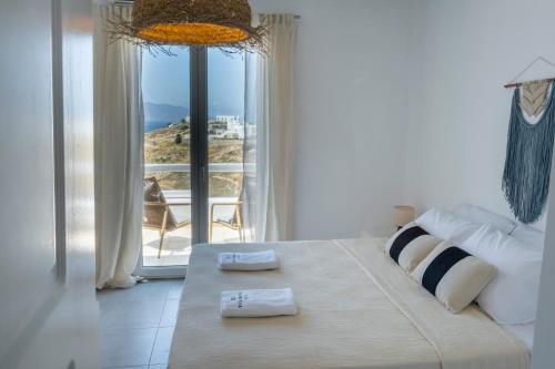 sypialnia z łóżkiem i widokiem na ocean w obiekcie Thalia Luxe 4-Bedroom Pool Villa w mieście Mykonos