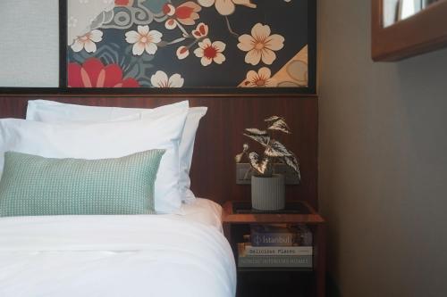 a bedroom with a bed with a flower picture on the wall at STORIES Joo Chiat, a Hotel by Cove - Paya Lebar, Singapore - NEWLY RENOVATED in Singapore