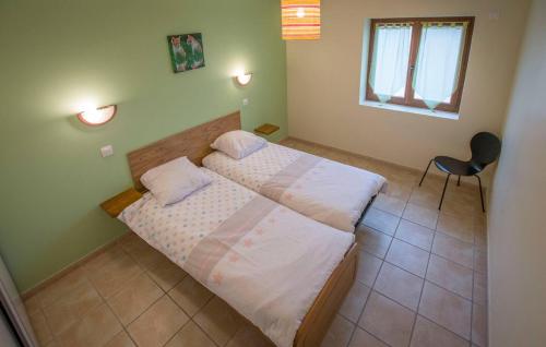 une petite chambre avec deux lits et une chaise dans l'établissement Gite à la ferme - 240m2 - billard - babyfoot, à Beauvoir-de-Marc