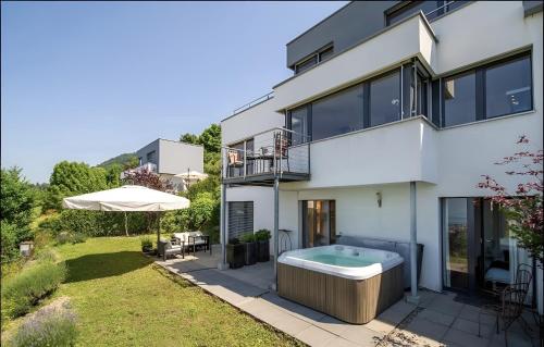 a white house with a hot tub in the yard at Panoramic Holiday Villa in Montreux in Montreux