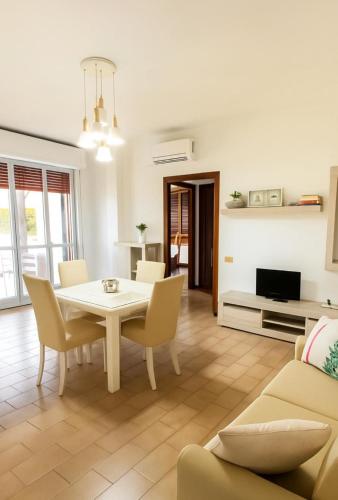 Una sala de estar con una mesa y sillas blancas. en DreamLiving Vasto 1st, en Vasto
