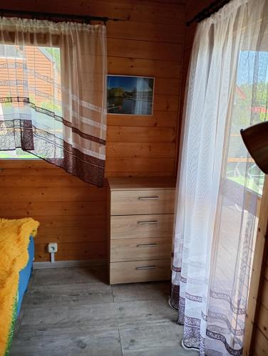 a bedroom with a bed and a window at Domek letniskowy w Nadolu nad jeziorem Żarnowieckim in Nadole