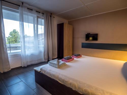 a bedroom with a large bed and a large window at Alexander in Shkorpilovtsi