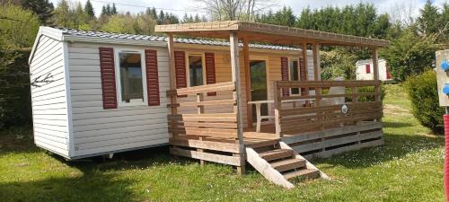 a large wooden cabin with a porch and a deck at Camping Le Balcon de Chartreuse in Miribel-les-Échelles
