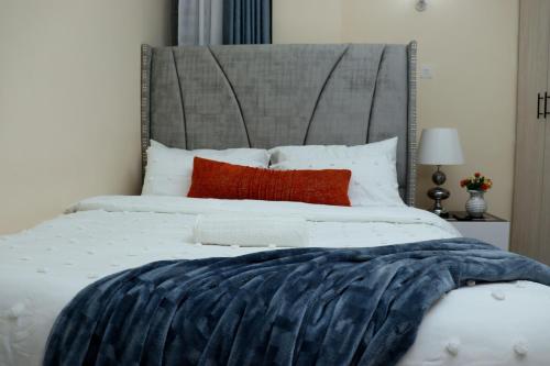 a bedroom with a large white bed with red pillows at The Swanky Crib in Ruiru