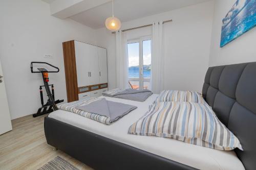 a bedroom with a bed and a large window at Apartmani Katarina in Pupnat