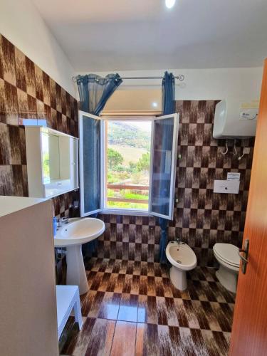 a bathroom with two sinks and a window at Two Steps From The Sea in Scopello