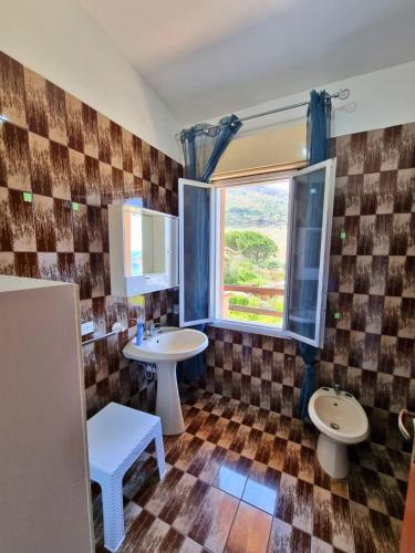 a bathroom with two sinks and a window at Two Steps From The Sea in Scopello