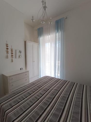a bedroom with a bed and a dresser and a window at Chiaro di Luna - Appartamento Luna Crescente in Paestum