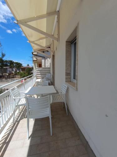 a row of tables and chairs on a balcony at Chiaro di Luna - Appartamento Luna Crescente in Paestum