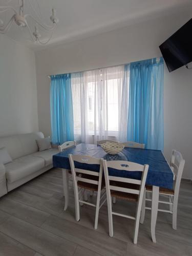 a dining room with a blue table and chairs at Chiaro di Luna - Appartamento Luna Crescente in Paestum