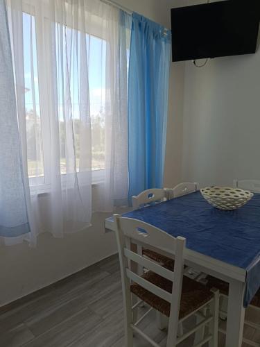 a dining room table with chairs and a blue table and window at Chiaro di Luna - Appartamento Luna Crescente in Paestum