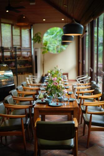 a dining room with a long table with flowers on it at The Apsara Lodge-Airport or TS Free pick-up over 3 nights in Yangshuo