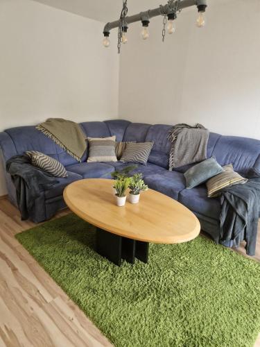 a living room with a blue couch and a table at Charming apartment in the countryside in Calden