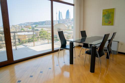 a table and chairs in a room with a large window at Sunday Hotel & Apartments in Baku