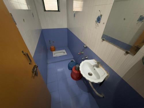 a blue and white bathroom with a sink at Hotel Temple Sai in Shirdi
