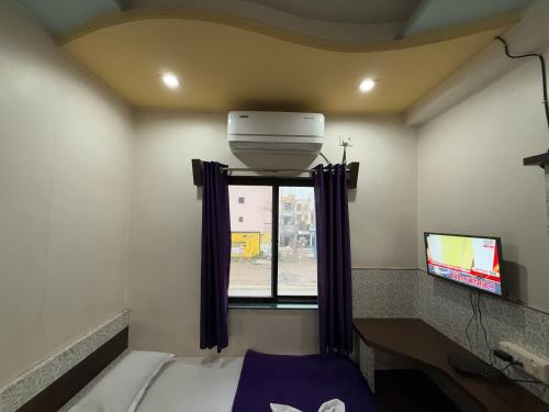 a small room with a bed and a window at Hotel Temple Sai in Shirdi