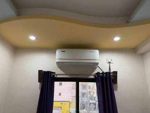 a printer on a shelf in a room with a window at Hotel Temple Sai in Shirdi